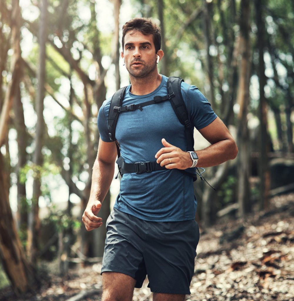 Cropped shot of a handsome young man running during his hike in the mountains.